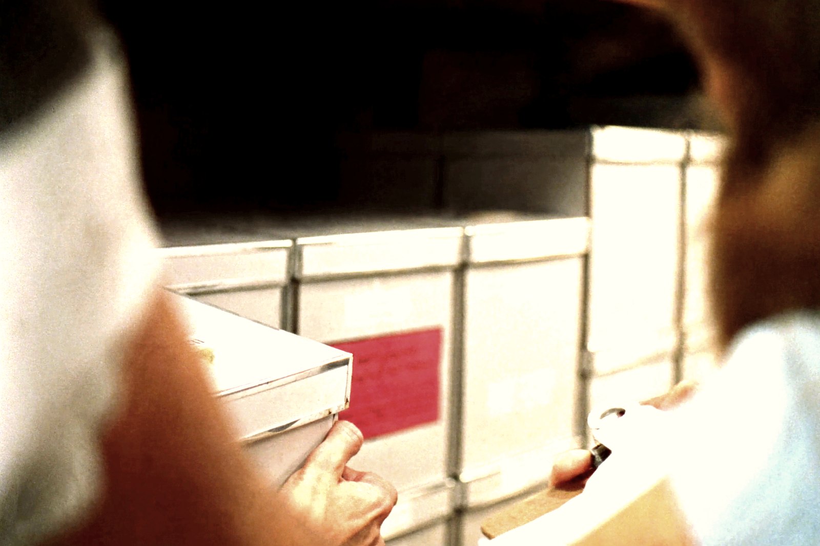 An archive box being placed onto a numbered shelf position