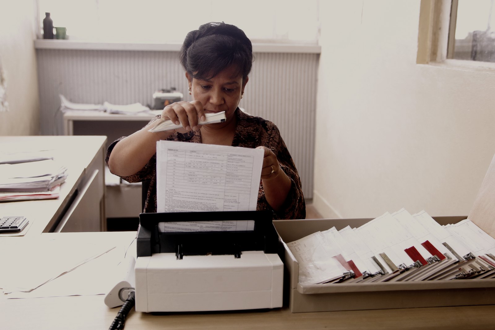 A records administrator scanning a page at her desk
