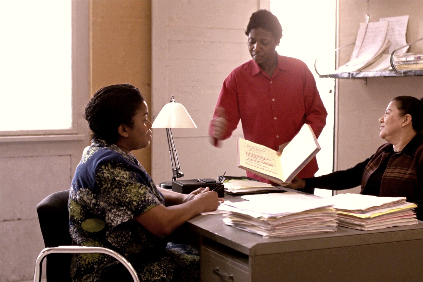 Two colleagues working through a stack of files together at a desk