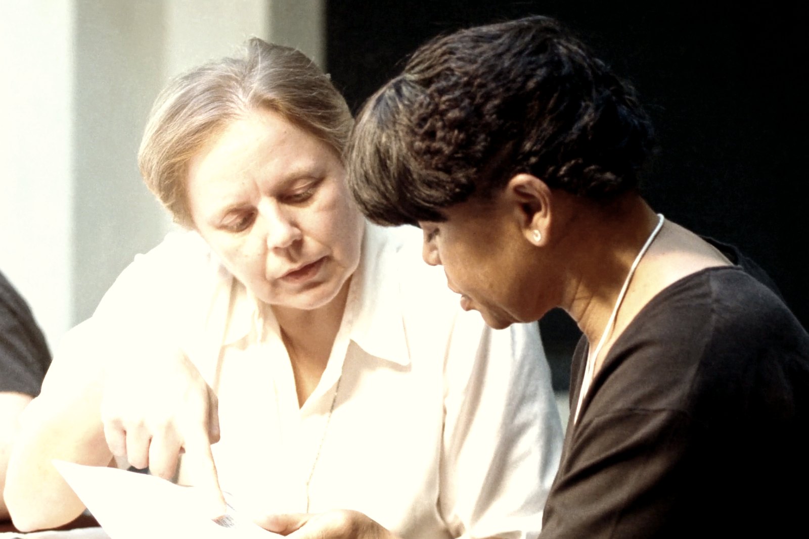 Two colleagues going through a printed page together at a table